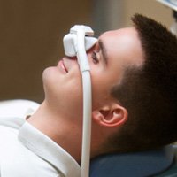 Man smiling while inhaling nitrous oxide in treatment chair
