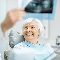 An older woman smiling with a dentist.
