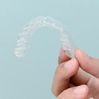 Closeup of patient holding clear aligner