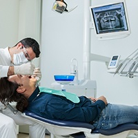 Implant dentist in Covington performing a dental exam