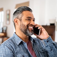 Man smiling while talking on phone