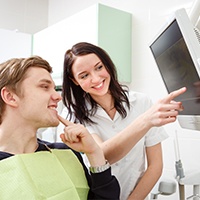 Patient and dental team member looking at dental x-rays