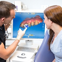 dentist showing a patient their digital impressions before CEREC dental crown placement