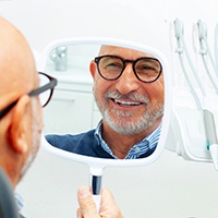 Happy senior patient looking in hand mirror