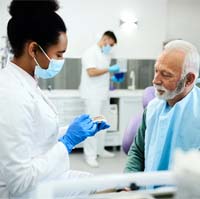 Dentist explaining cost of dentures in Covington to a patient