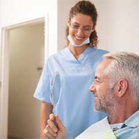 Denture dentist in Covington smiling with a patient