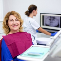 An older woman smiling at her dental appointment.