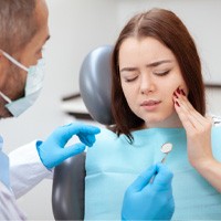 A woman suffering from a dental emergency