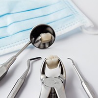 Covington dentist tools holding extracted tooth