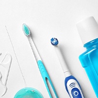Toothbrush alongside other oral hygiene supplies