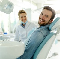 Smiling male dental patient in treatment chair