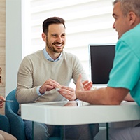 A dentist speaking to a couple about dental implants