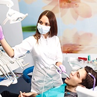 A dentist performing an intraoral exam on a patient