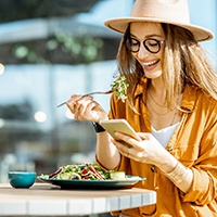 Woman smiling while eating lunch outside