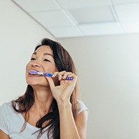 Woman brushing her teeth in bathroom