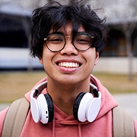 Closeup of teenage boy with black glasses smiling
