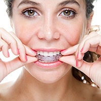 Woman placing Invisalign tray