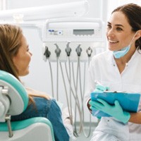 Dentist smiling while asking patient questions about medical history