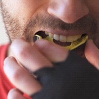 Closeup of man putting mouthguard in place before workout