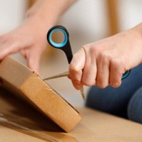 Person using scissors to open package