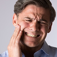 Man in pain holding jaw