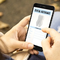 Patient using phone to learn about dental insurance coverage