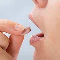 Woman taking oral sedative pill