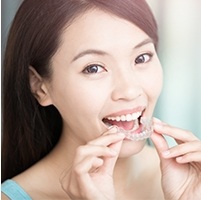 Woman placing Invisalign tray