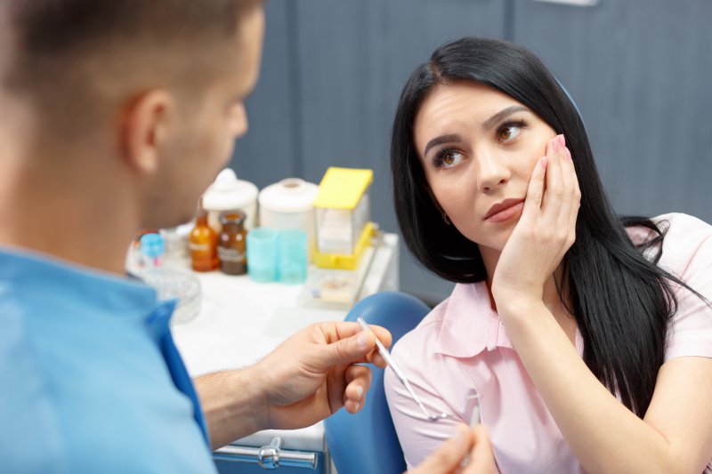 A woman with TMJ disorder listening to a dentist.