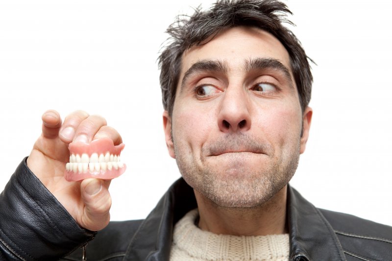 man holding dentures in Covington