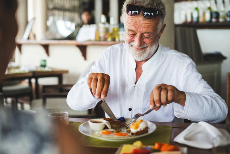 man eating with dentures in Covington