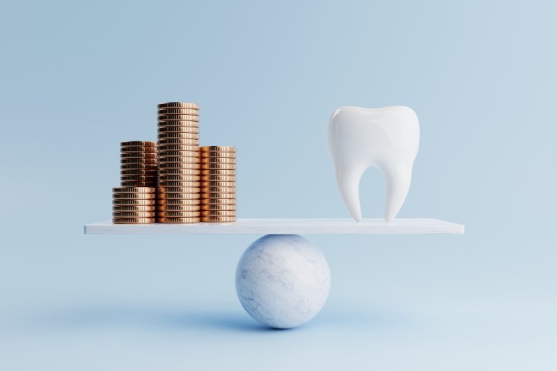 A tooth and a stack of coins balancing on a scale.