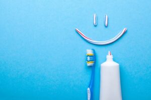 Smiley face made out of toothpaste with a toothbrush under it